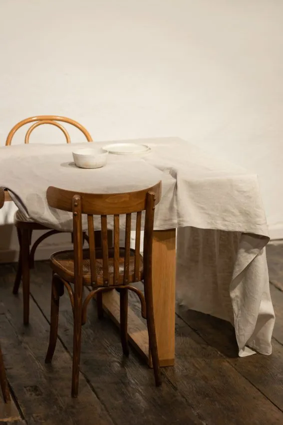 ľanový obrus v béžovej farbe ľanu s dreveným stolom a s drevenými stoličkami